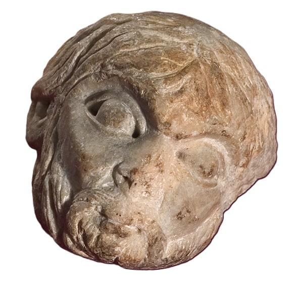 Fragment escultòric de pedra amb un cap masculí barbut d'expressió serena.