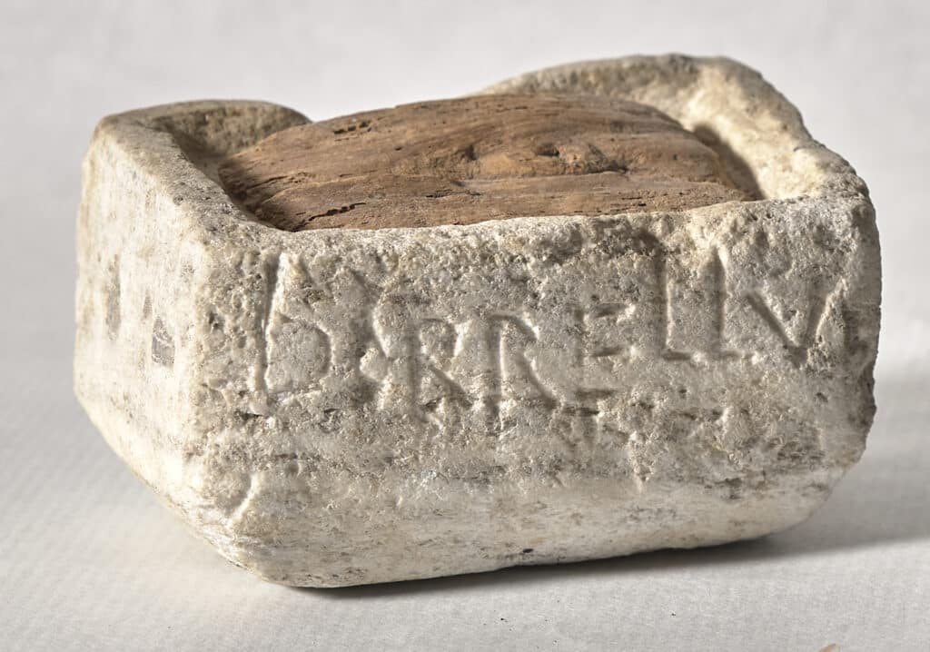 Lipsanoteca de pedra rectangular amb inscripció en llatí i interior de fusta