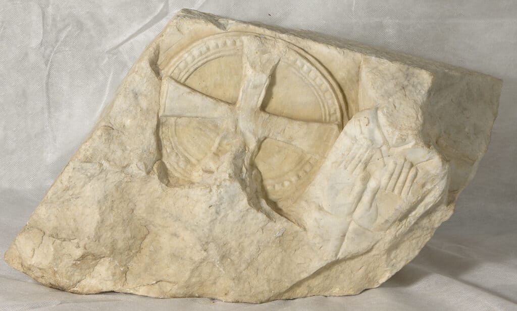 Fragment de relleu en pedra calcària on s'intueix Crist a la creu i diversos personatges