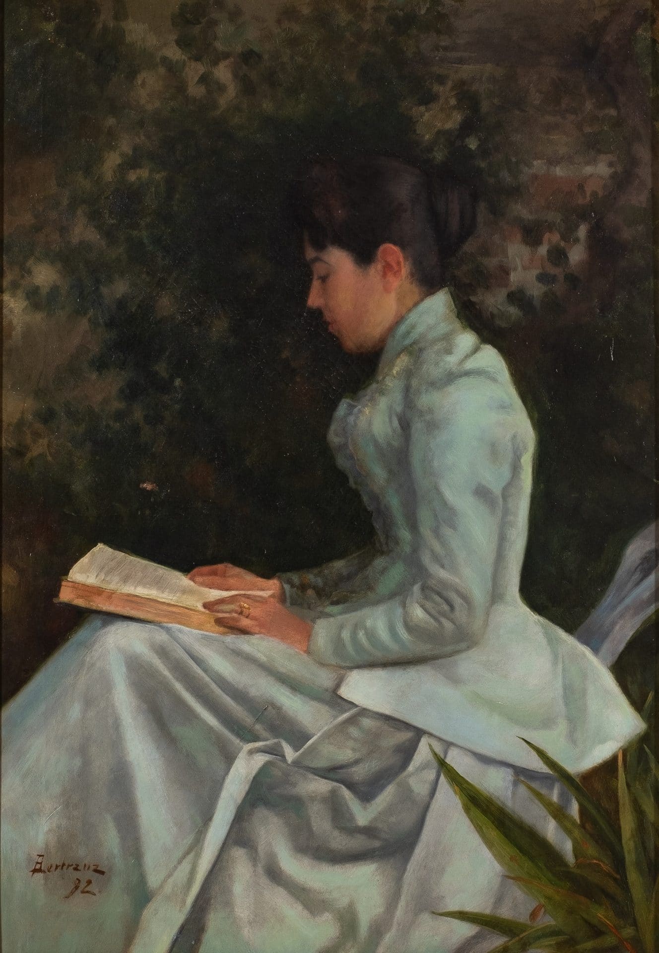 Dona asseguda llegint un llibre en un jardí, vestida amb un elegant vestit clar del segle XIX, representada de perfil.